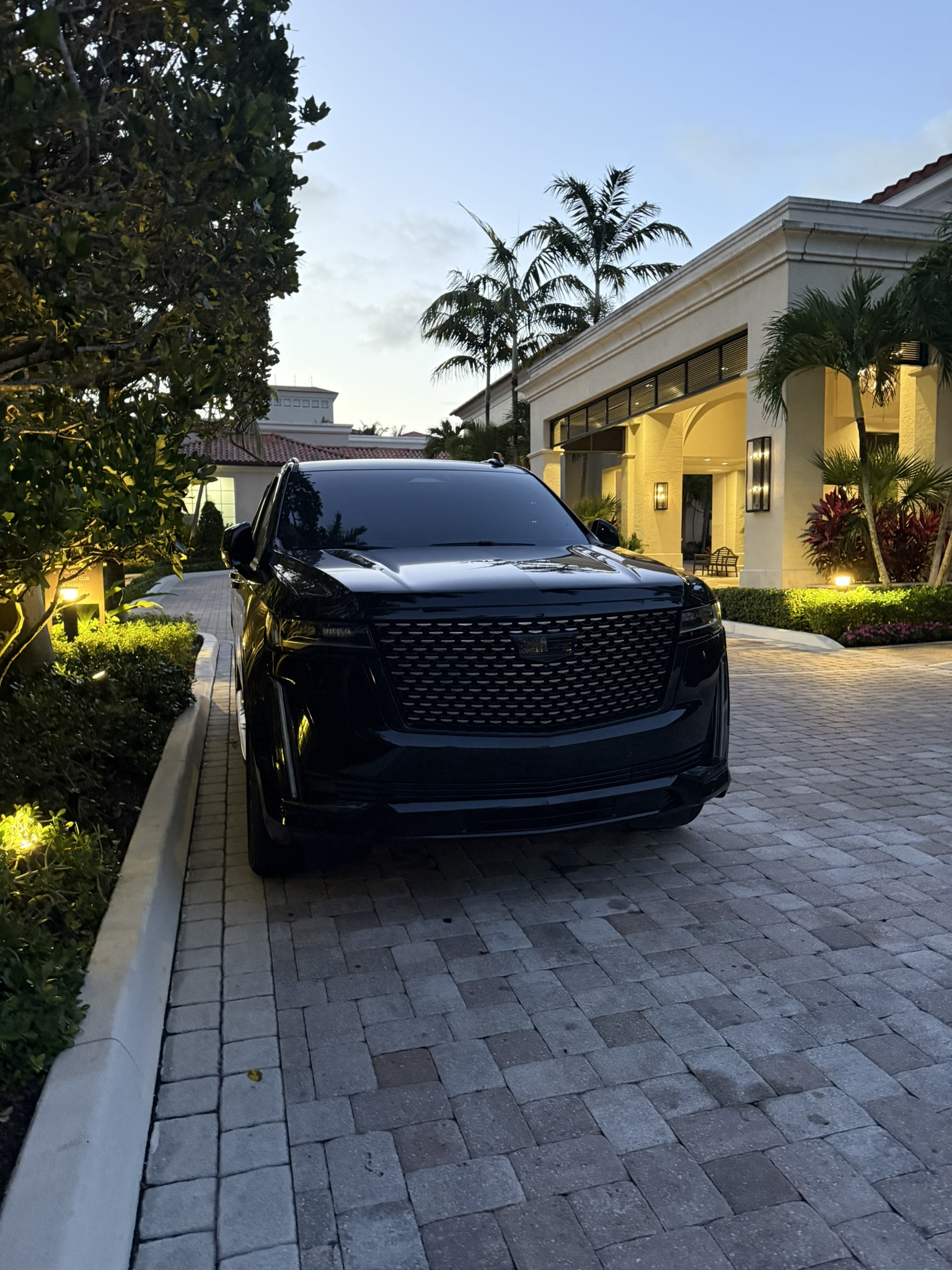Black Cadillac Escalade waiting at a private club entrance