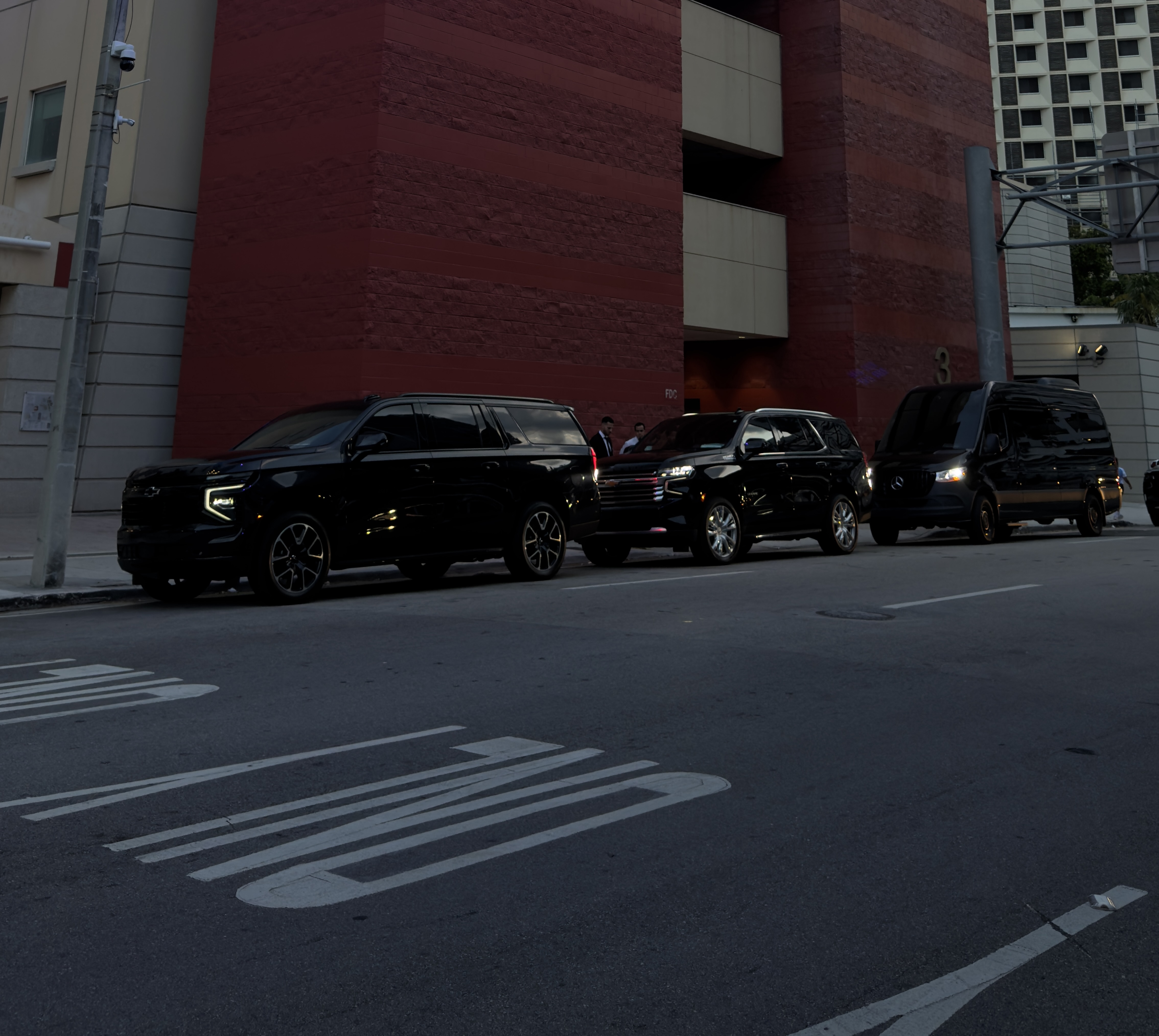 Aura Limo Miami chauffeurs with the black SUV and Sprinter fleet on a Miami street