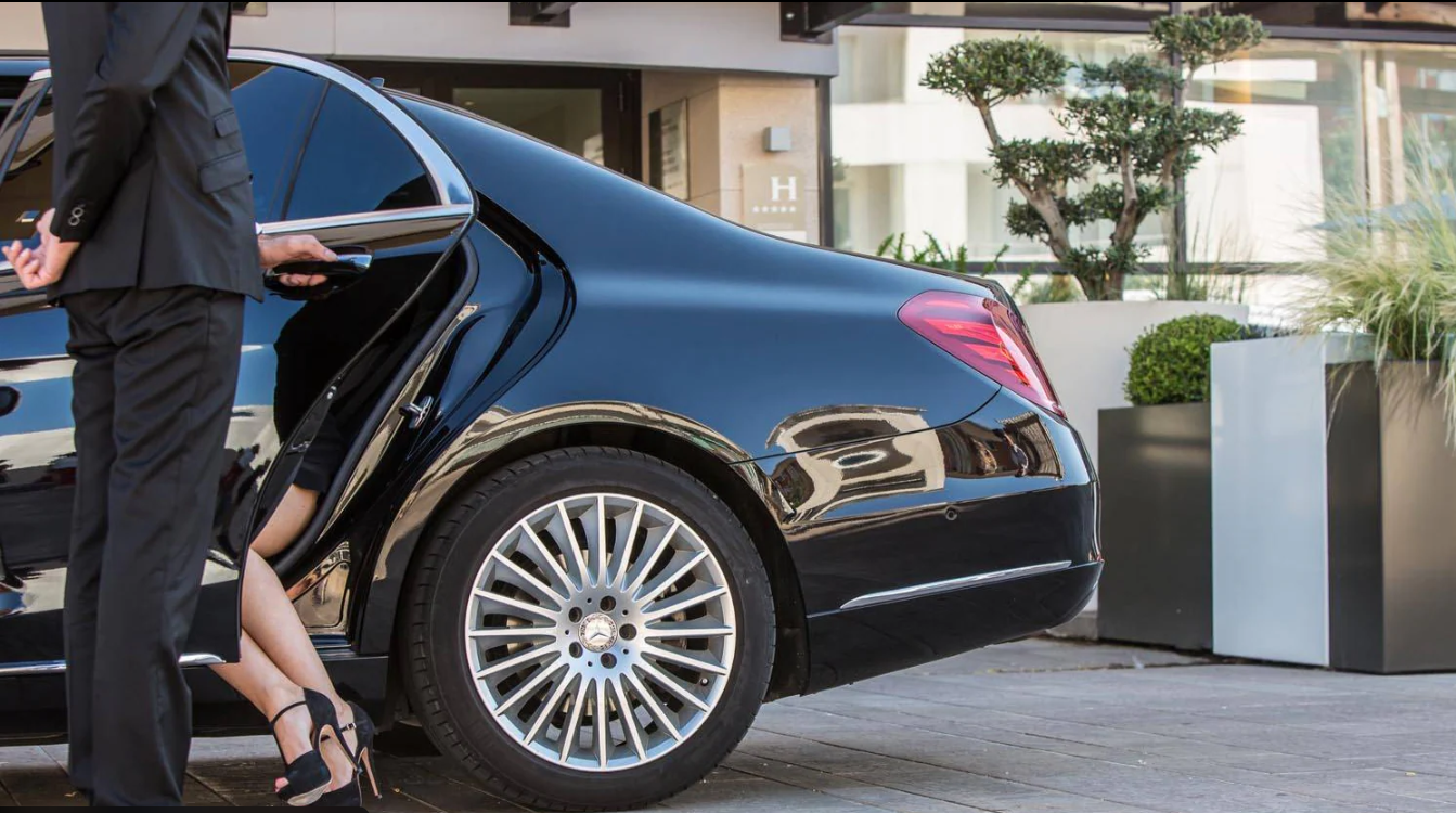 Chauffeur opening door of luxury sedan