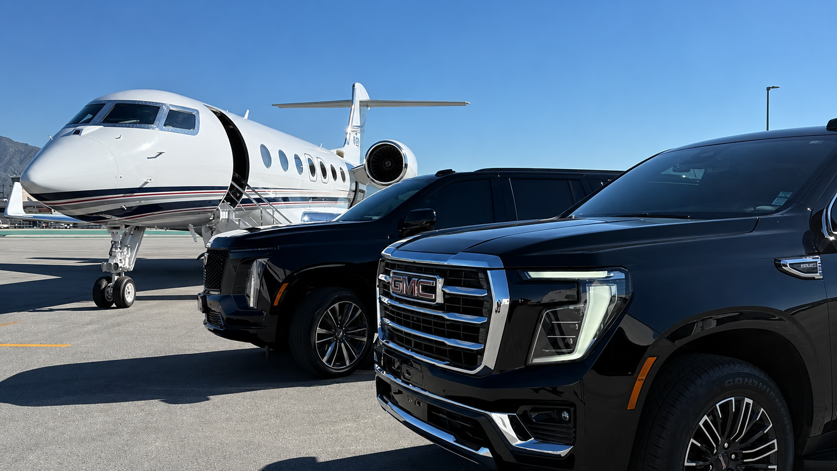 Luxury SUVs beside a private jet